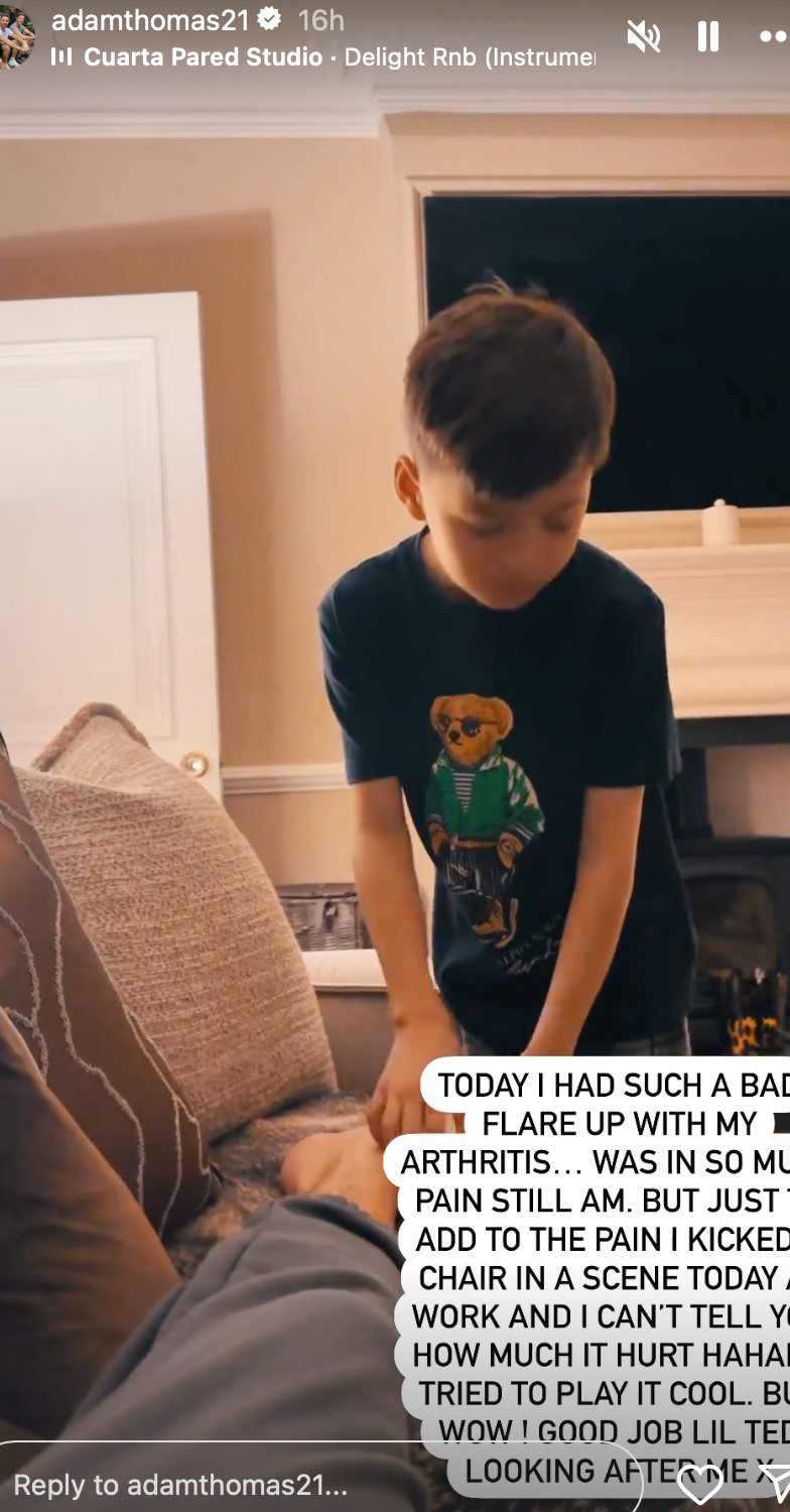 Adam Thomas laid on the sofa whilst his son rubs his feet