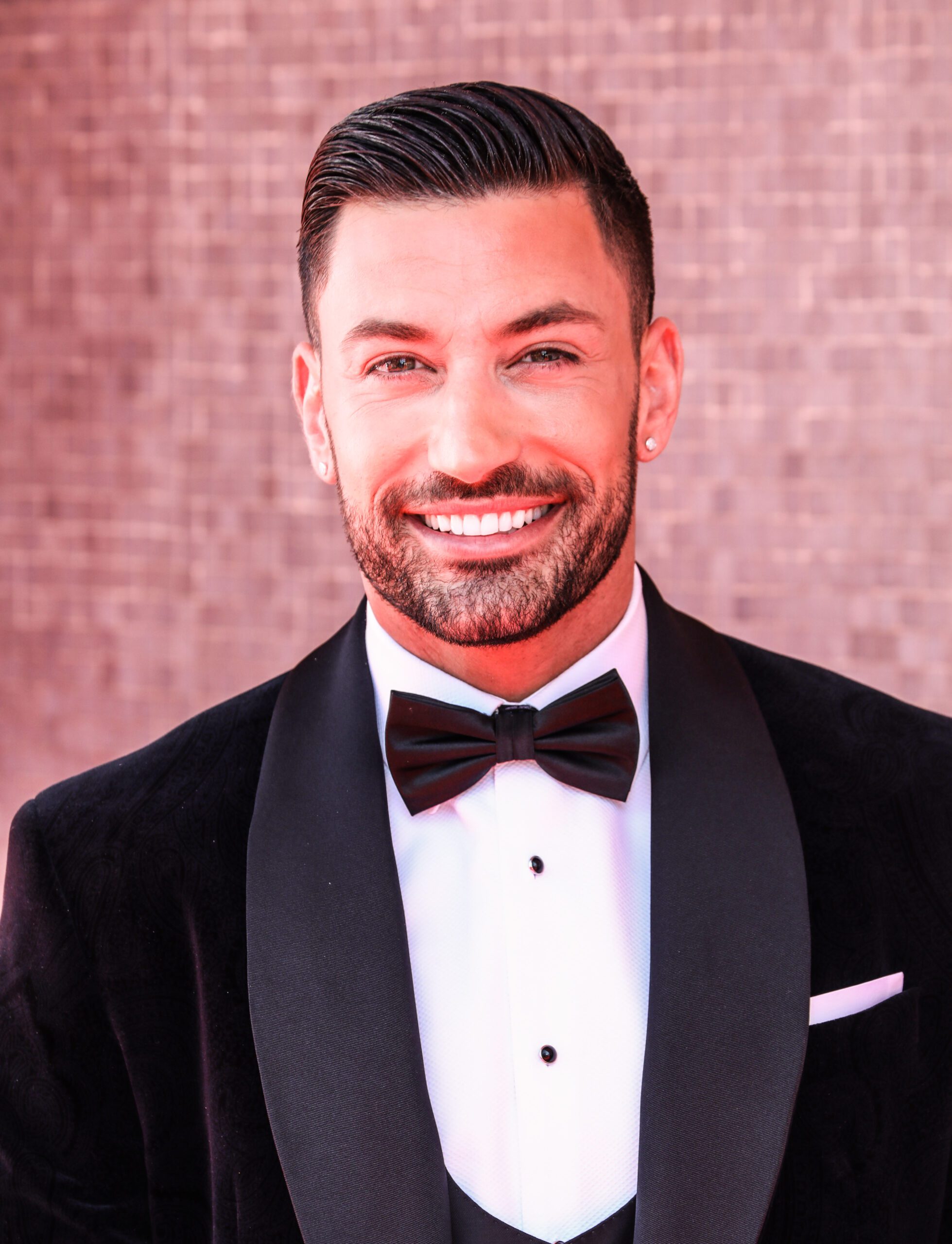 Giovanni Pernice smiling against a glittery background