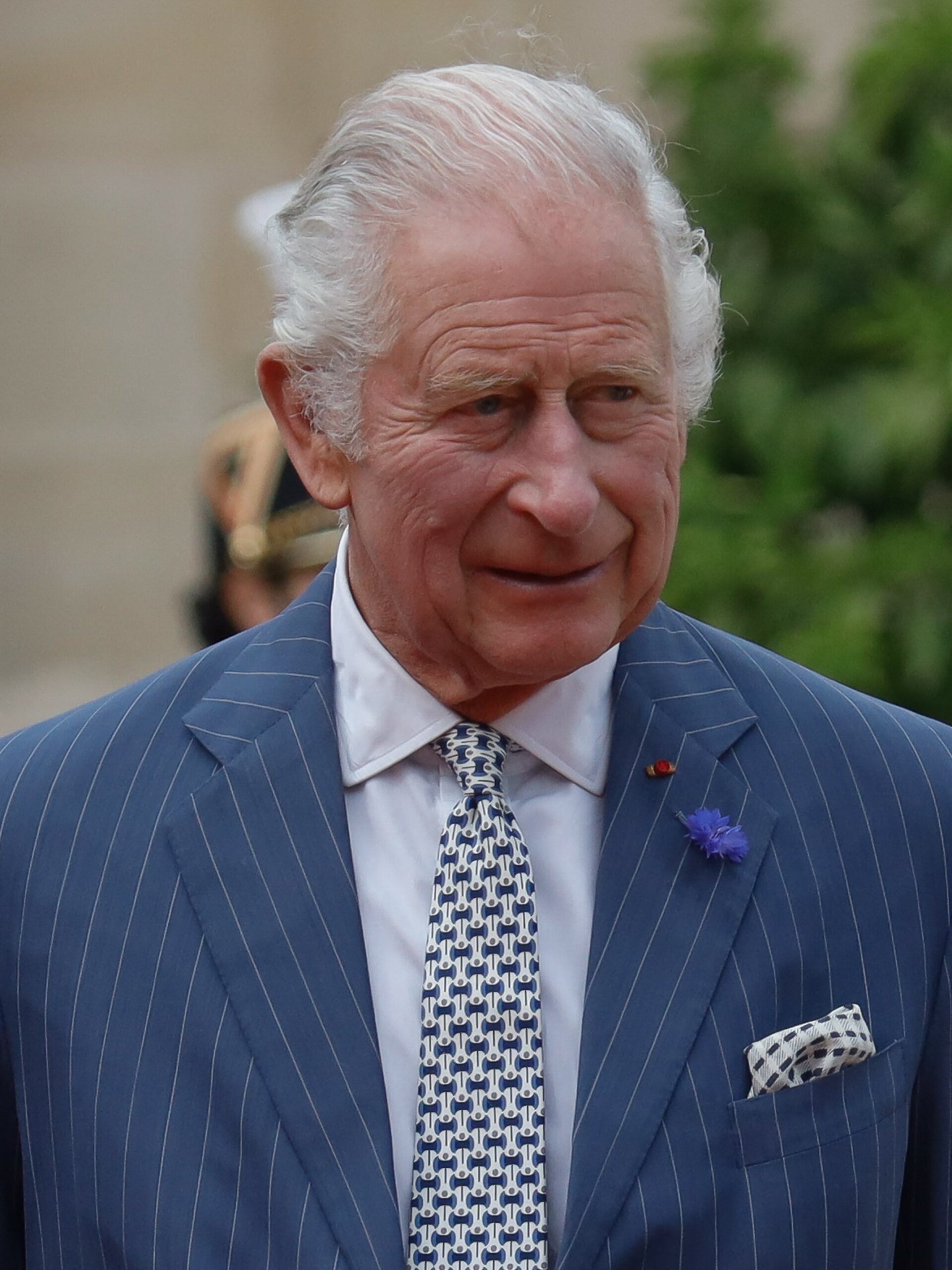 King Charles smiling in blue suit