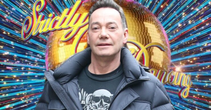 Craig Revel Horwood in front of Strictly logo