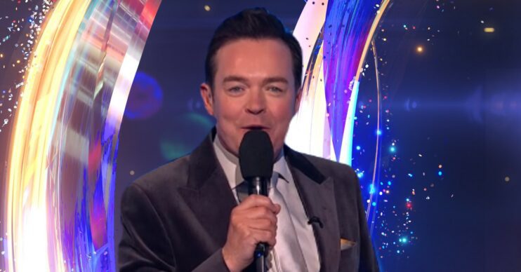 Stephen Mulhern speaking into microphone in front of Dancing On Ice logo