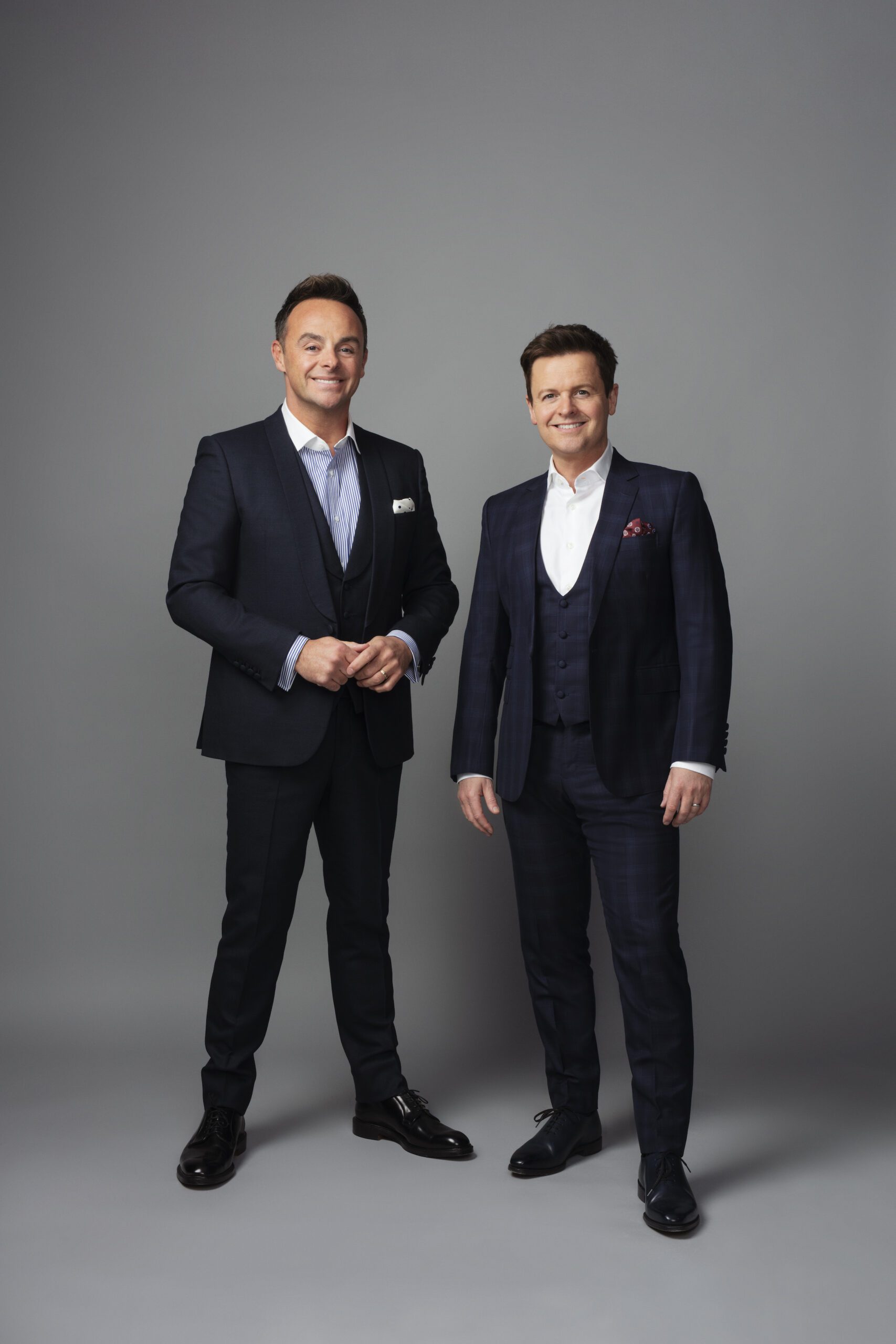 Ant and Dec wearing suits against a grey background