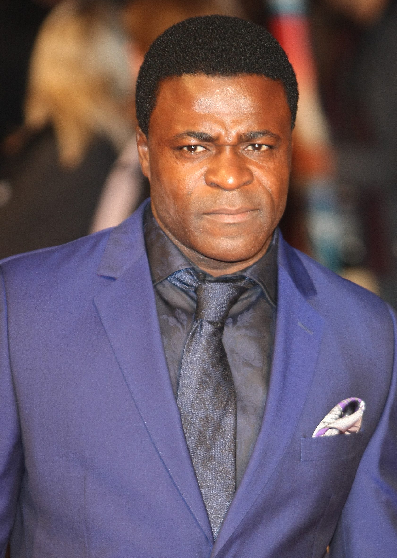 Danny Sapani, wearing a blue suit with black shirt and tie, at the film premiere of Trance in 2013