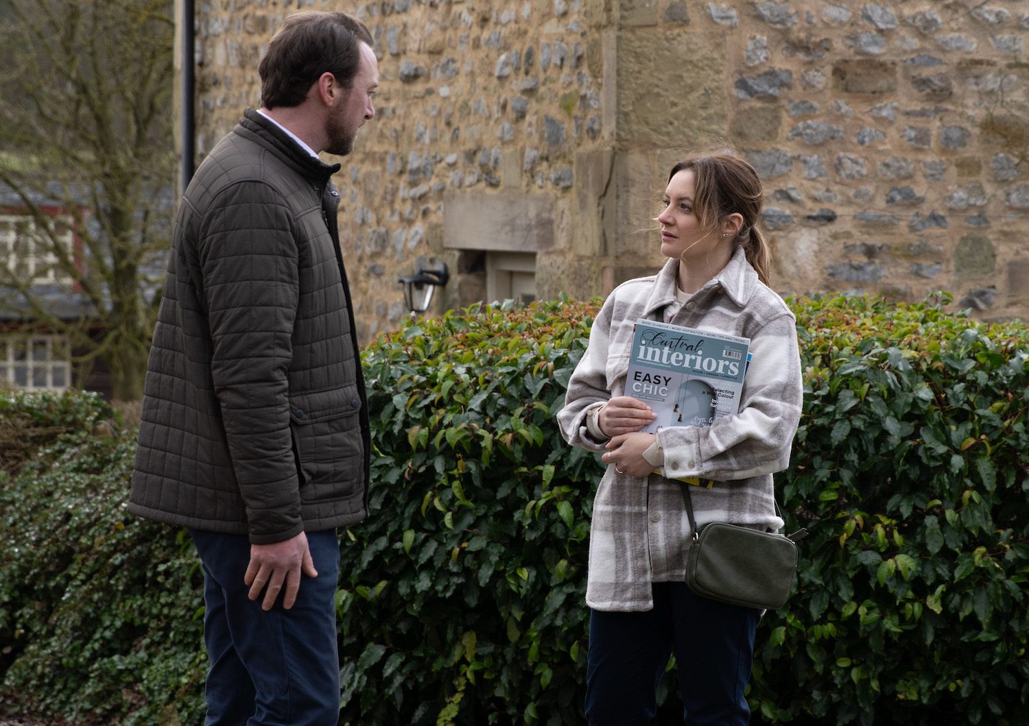 Emmerdale's Liam and Ella are talking to each other outside whilst Ella holds some magazines
