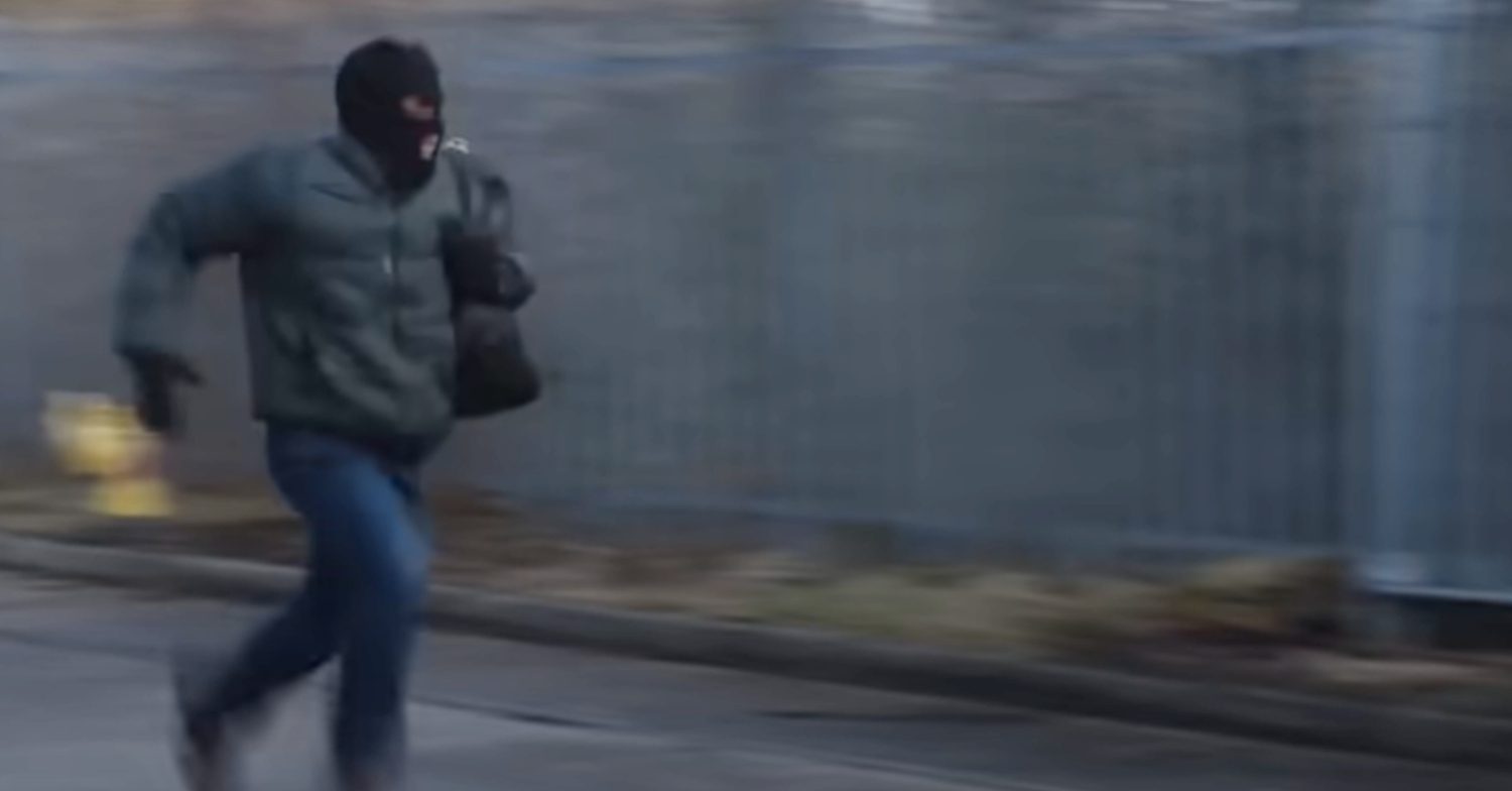 Coronation Street's Damon is running with a mask on and a bag of cash