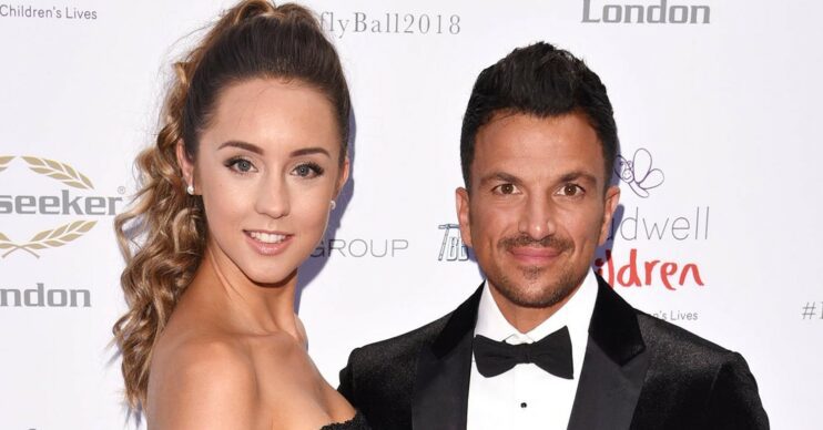 Emily Andre wearing a black mesh dress with Peter Andre in a black suit on the red carpet smiling