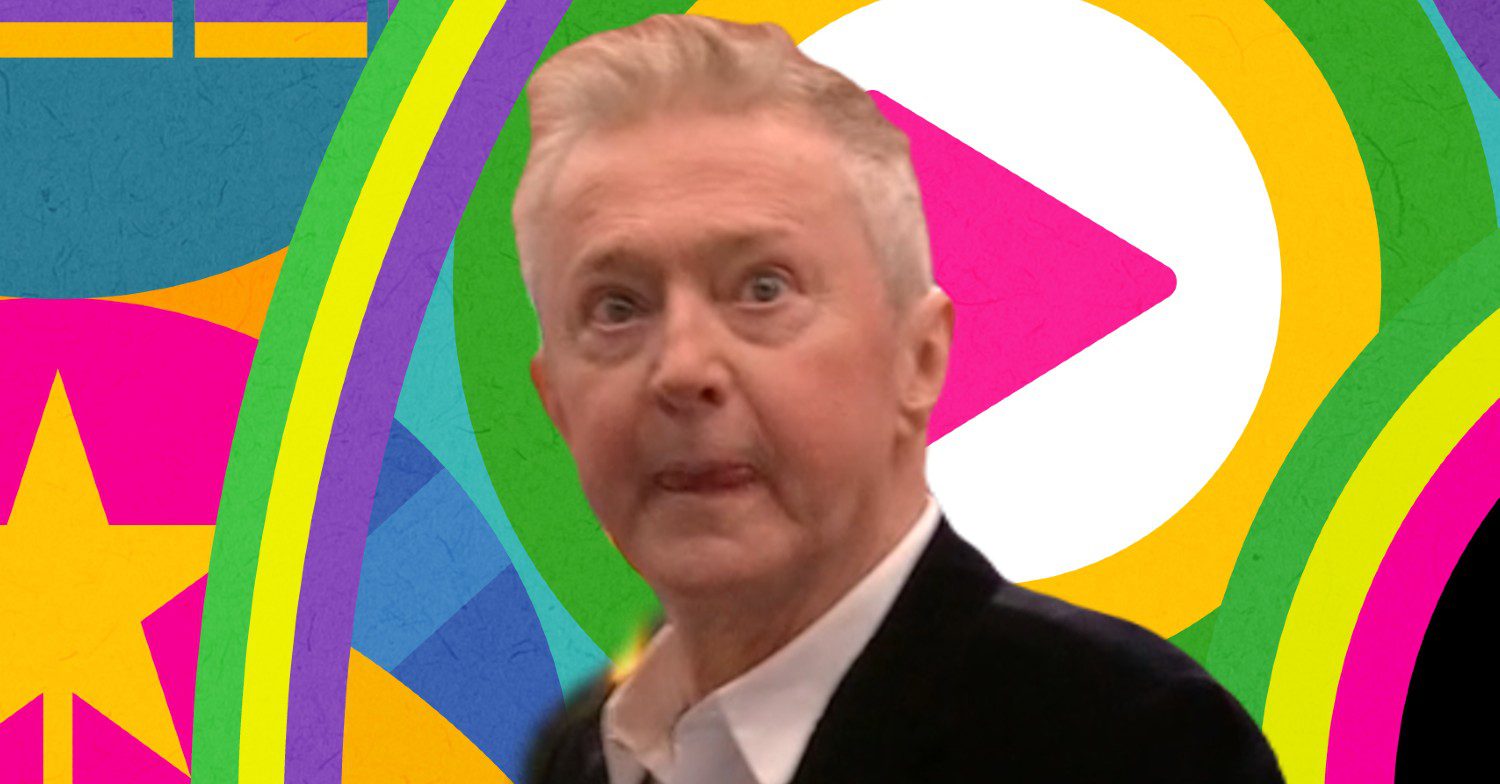 Louis Walsh looking serious in front of Celebrity Big Brother logo