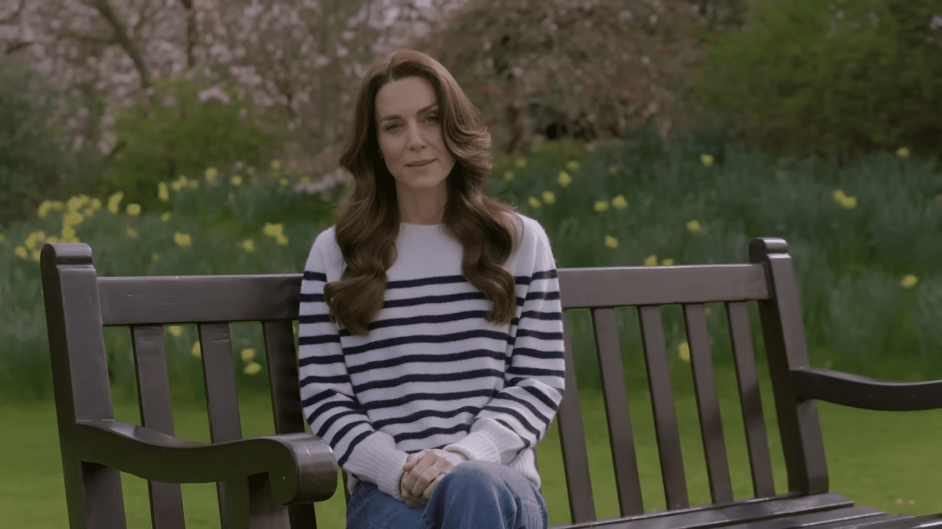 Princess Kate sitting on a bench in a striped top