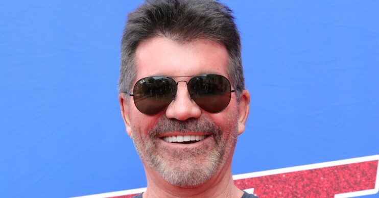 Simon Cowell smiling in sunglasses