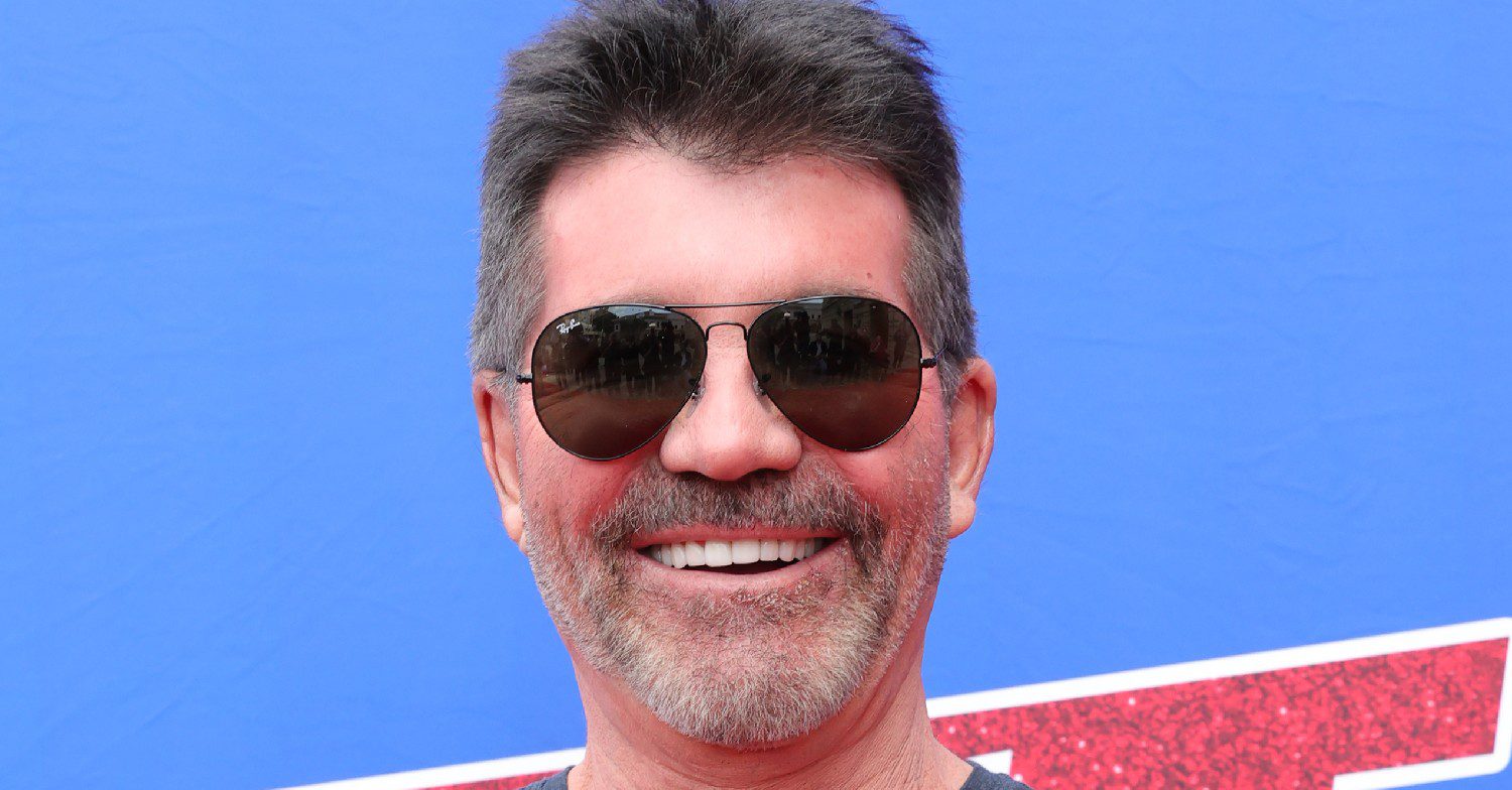Simon Cowell smiling in sunglasses