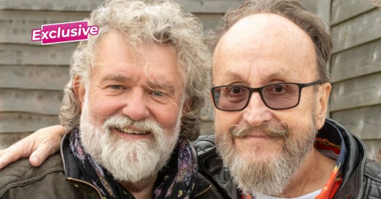 Si King and Dave Myers smiling against a fence