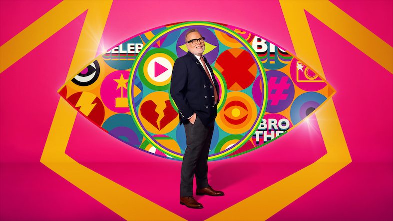 Gary Goldsmith standing against the pink Celebrity Big Brother logo