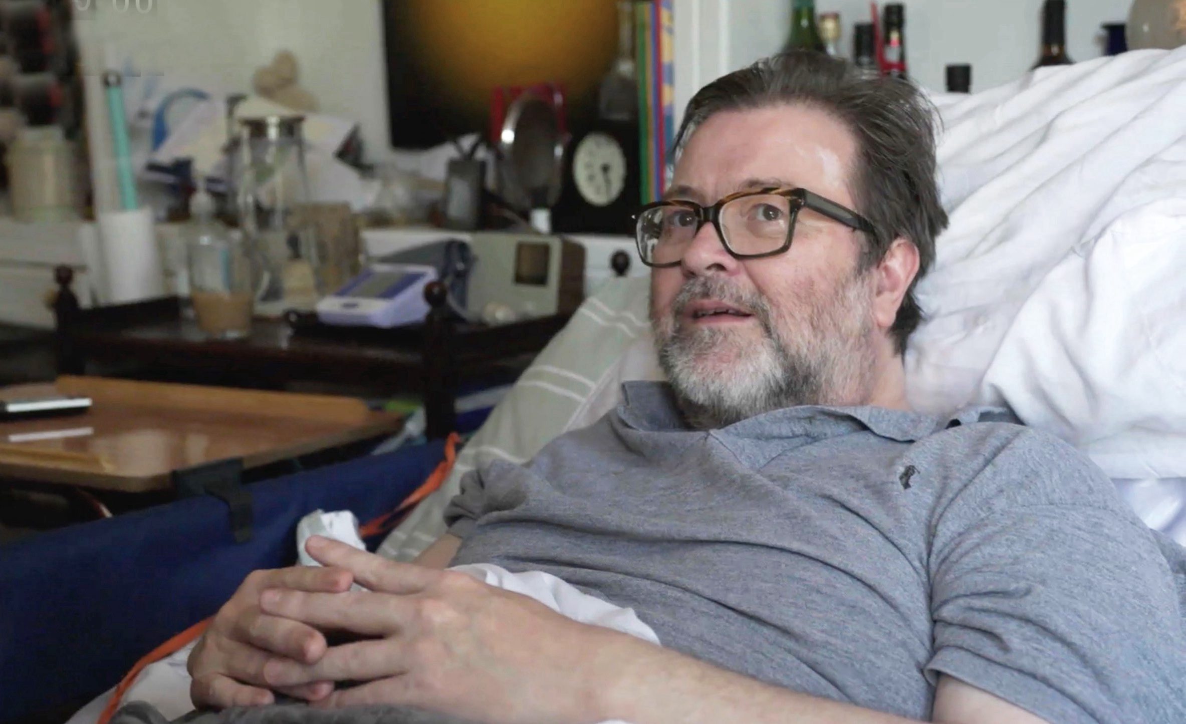 Derek Draper sitting up in a hospital bed