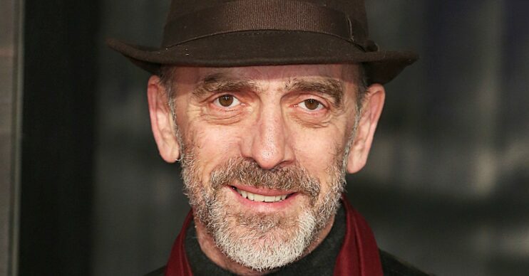 Adrian Schiller smiling in a hat
