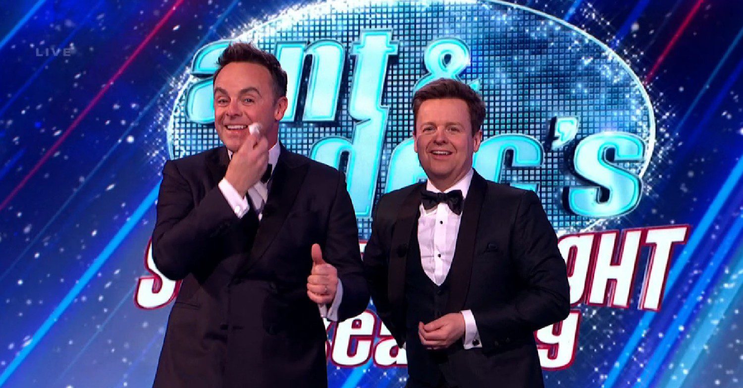 Ant touching his cheek with a tissue alongside Dec on Saturday Night Takeaway