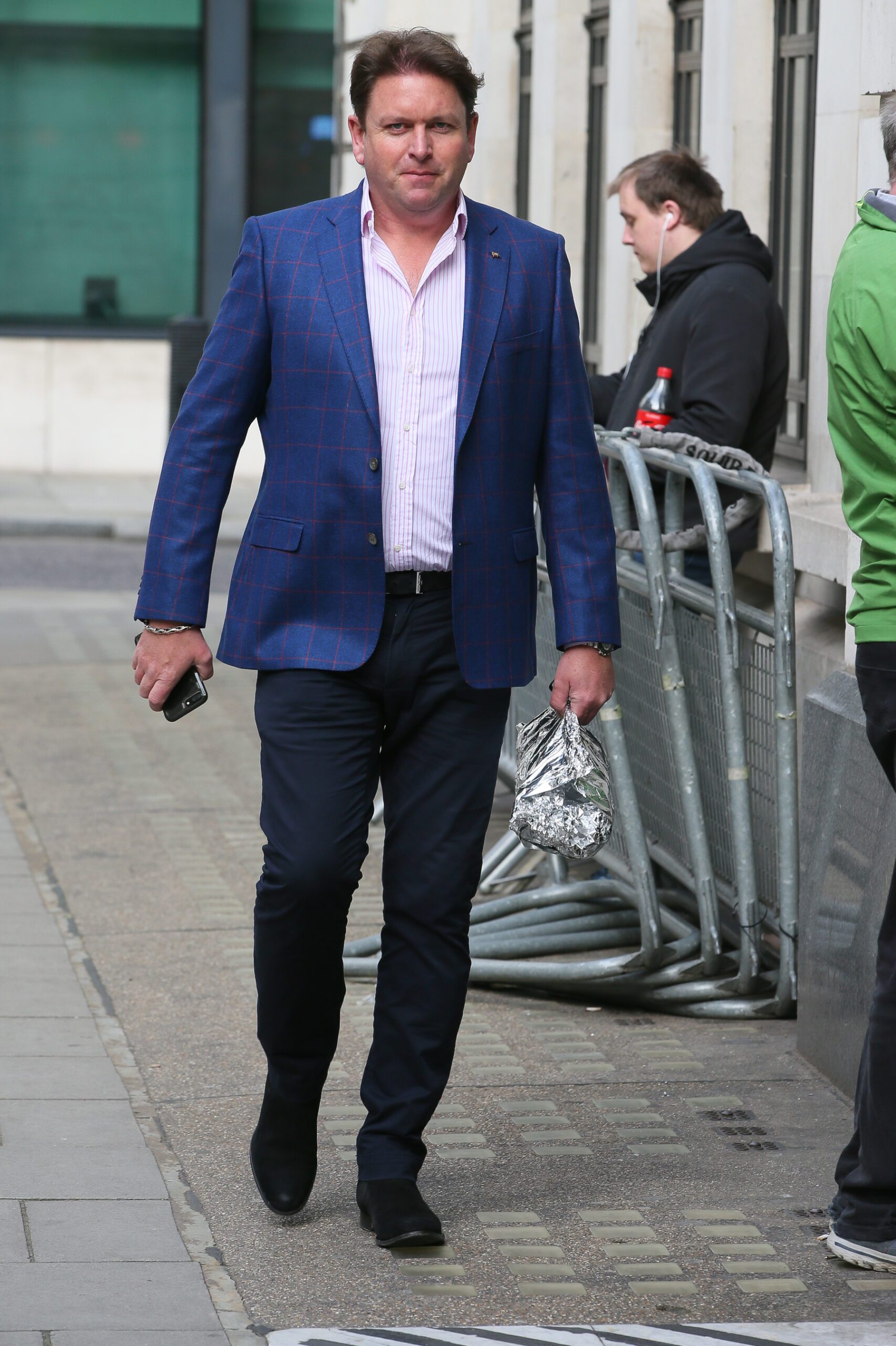 James Martin looking to camera while walking in the street