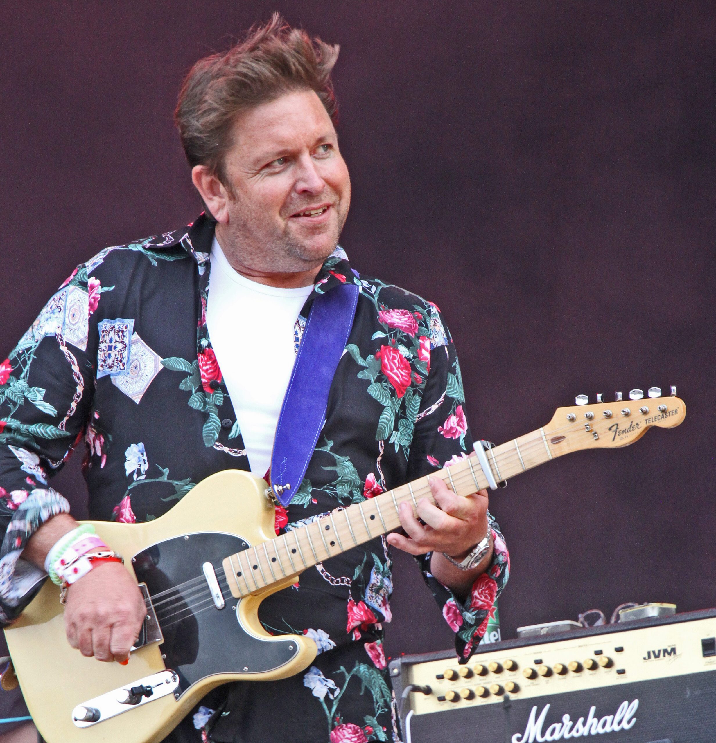 James Martin playing a guitar on stage in a flowery jacket