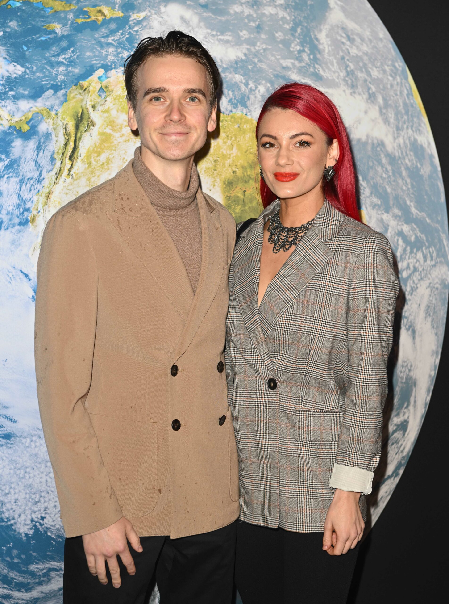 Joe Sugg and Dianne Buswell smiling and posing together on red carpet at BBC Earth experience launch
