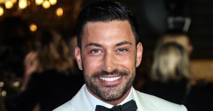 Giovanni Pernice smiling wearing white tuxedo and black bow tie