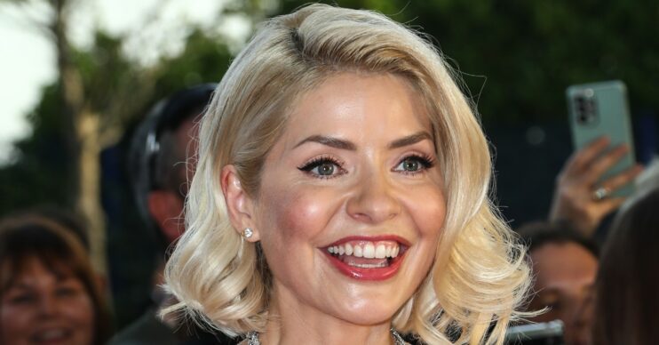 Holly Willoughby with hollywood style hair smiling at the camera