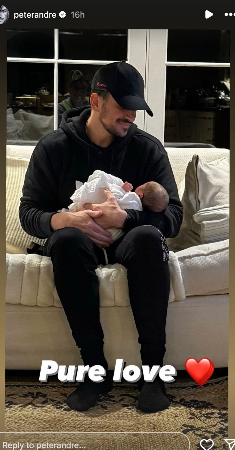 Peter Andre cradling newborn daughter and smiling
