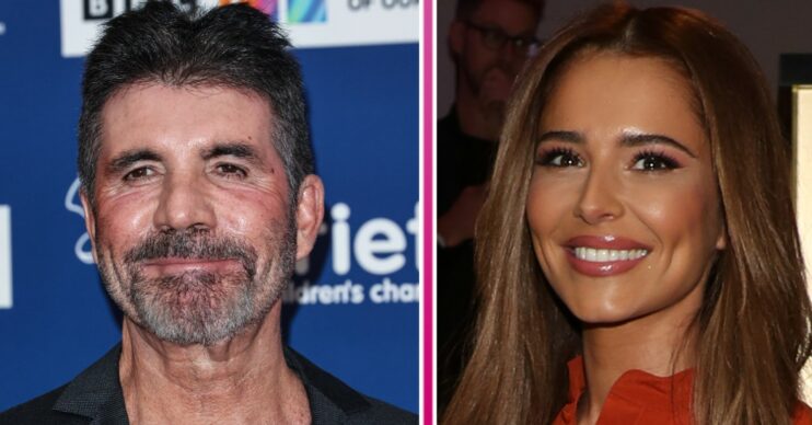 Simon Cowell smiling at camera wearing suit on red carpet beside Cheryl Tweedy smiling wearing red jumpsuit