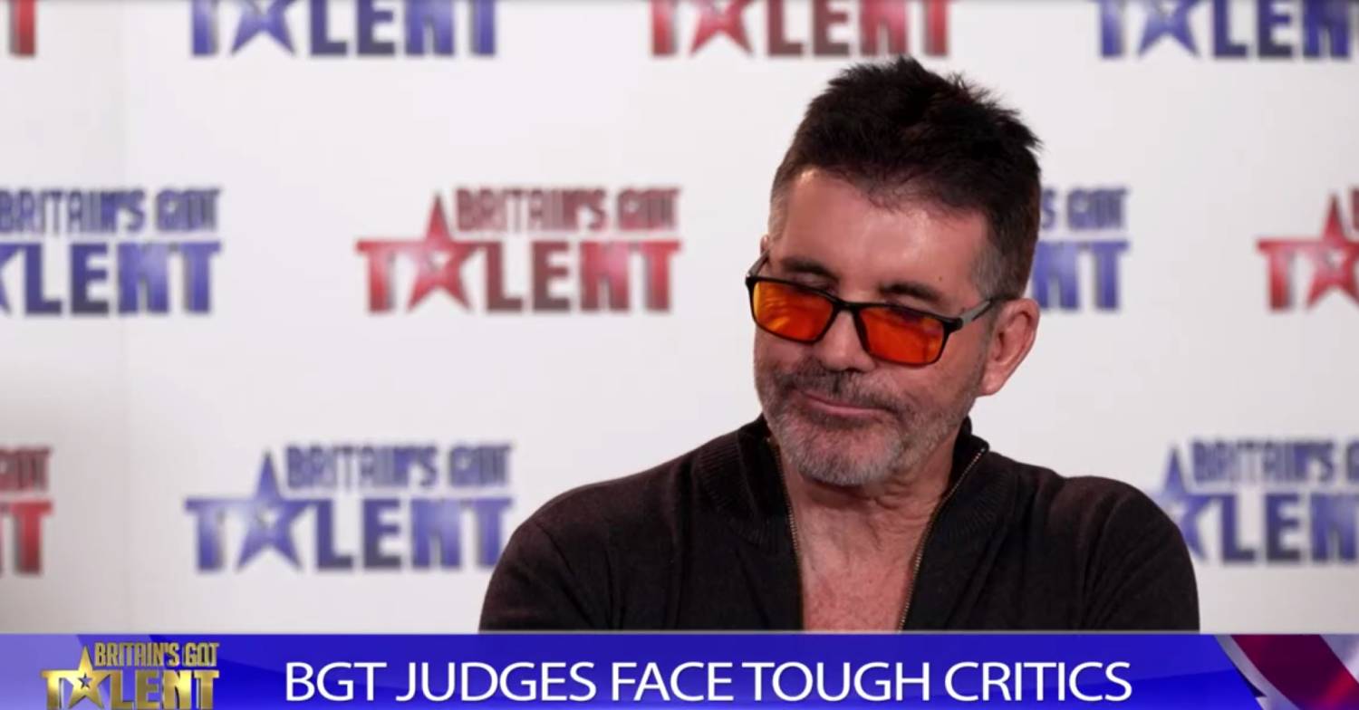 Simon Cowell looks downwards