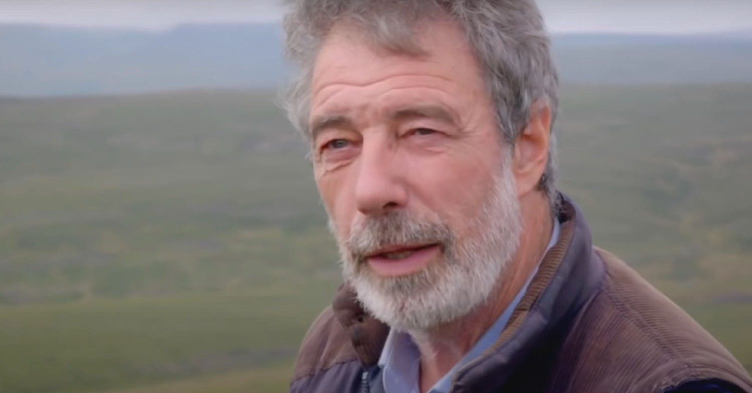 Clive Owen speaking to camera on the farm