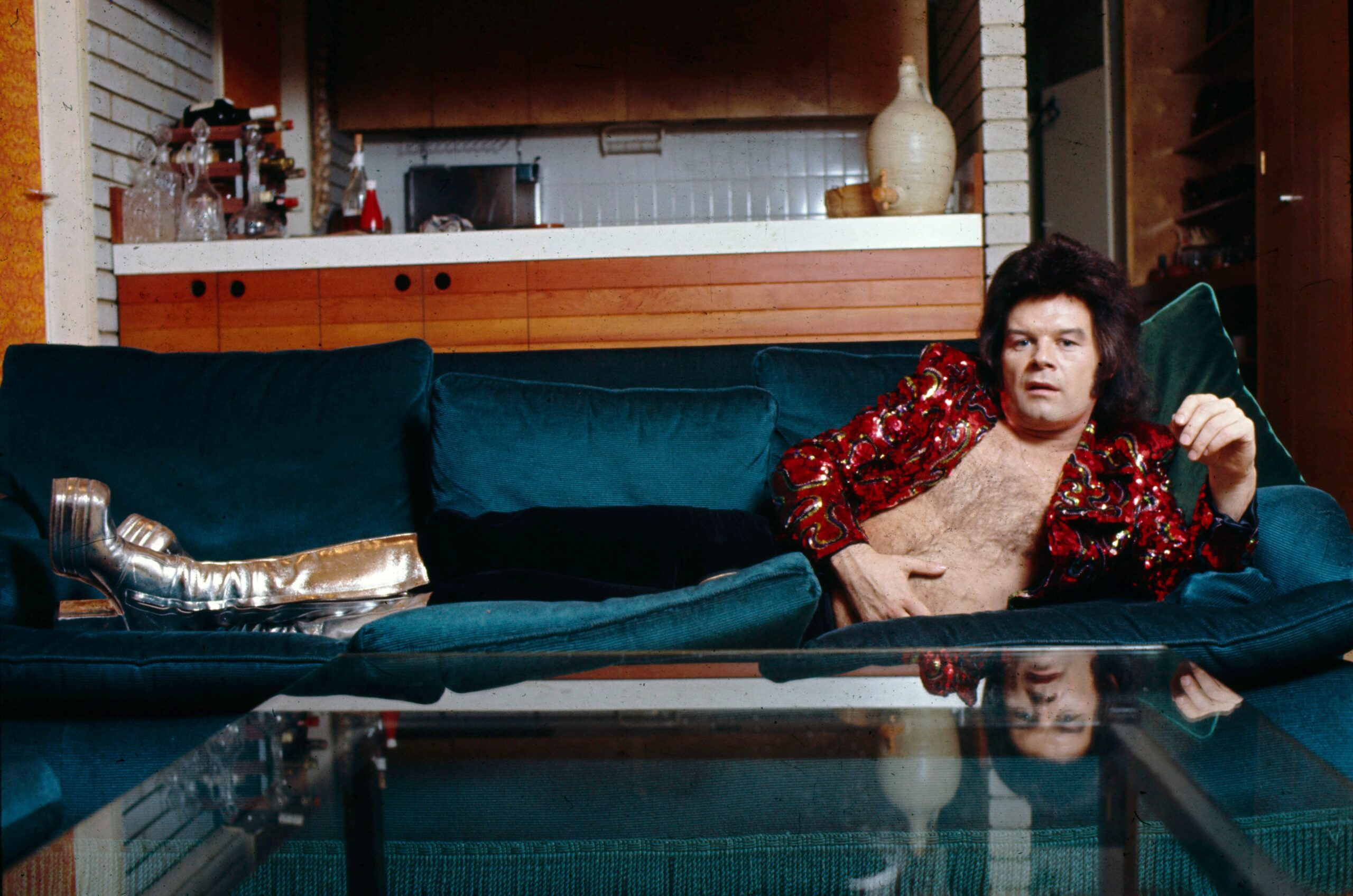 Gary Glitter lying on a sofa topless