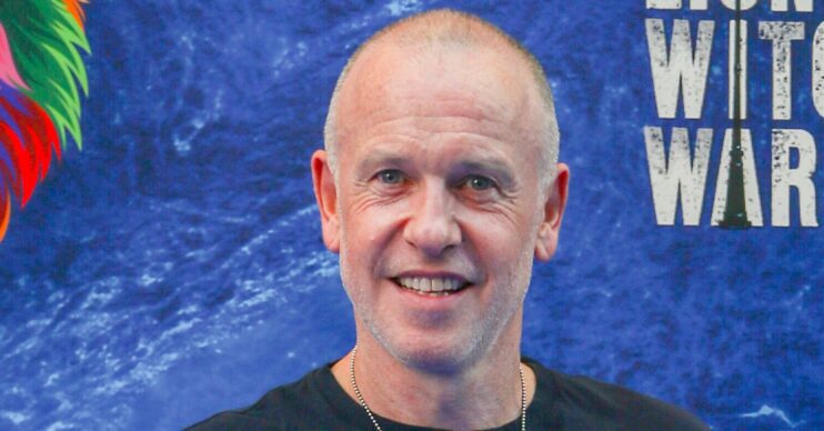 Tim Lovejoy smiling against a blue background