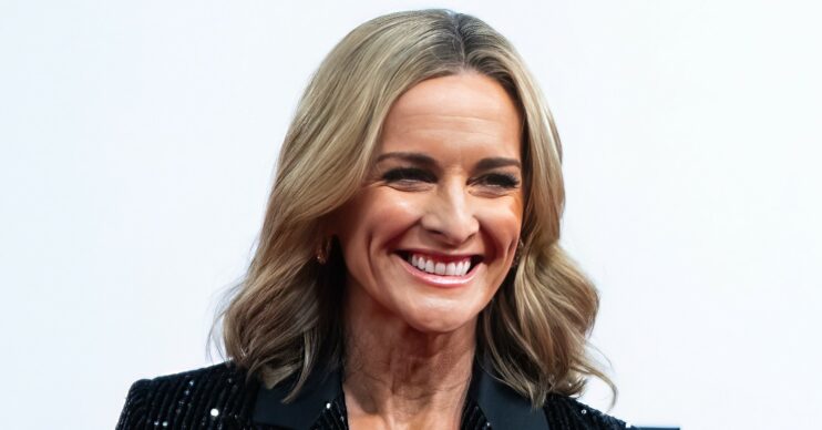 Gabby Logan smiling whilst wearing a sparkly suit