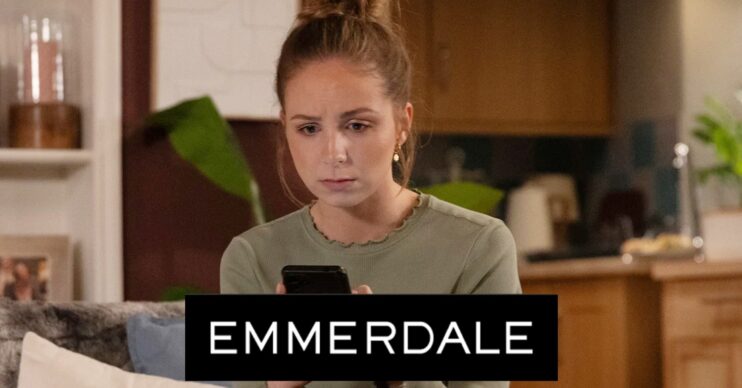 Belle looks worried as she looks at a phone on Emmerdale; logo inset (Credit: ITV/Composite: ED!)