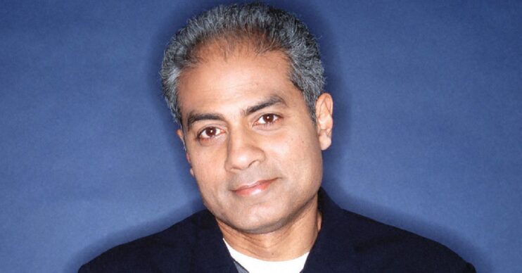 George Alagiah standing against a blue background