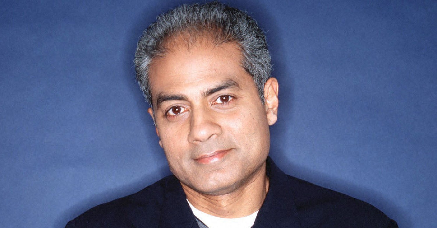 George Alagiah standing against a blue background