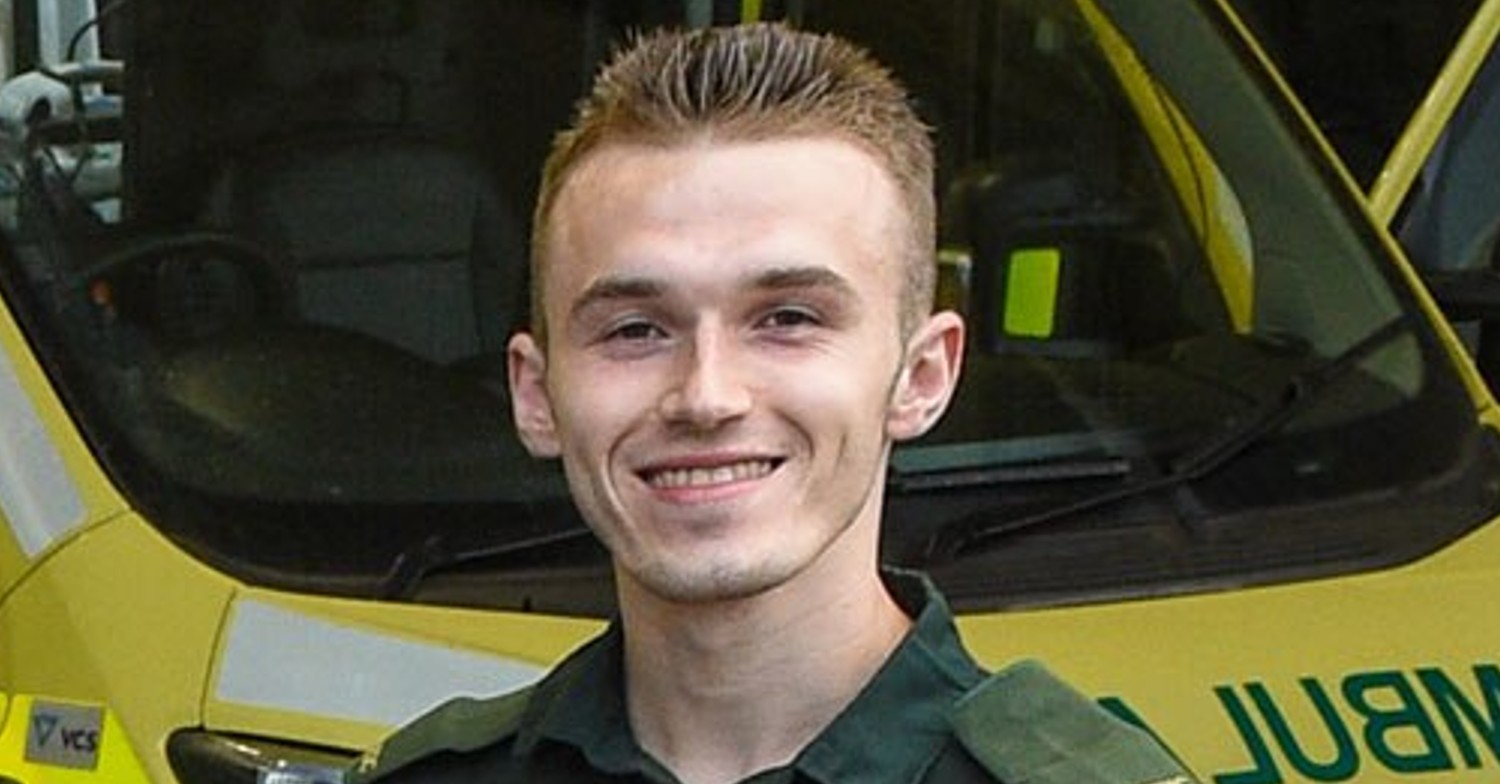 Dan Duffield smiling in front of an ambulance