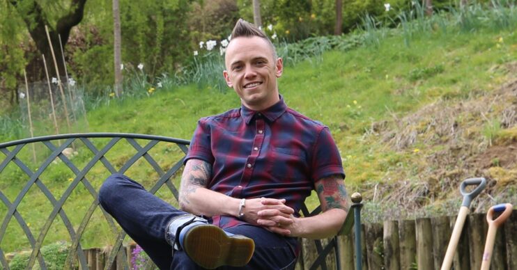 Lee Burkhill sitting with his legs crossed in a Garden Rescue promo