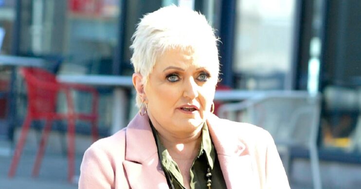 Linda Nolan with serious expression in pink coat on outing