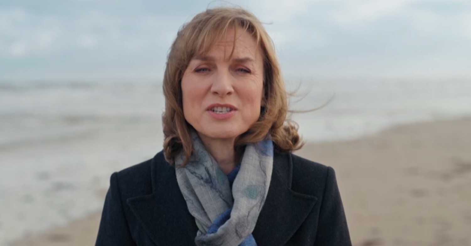 Fiona Bruce on a beach speaking to camera