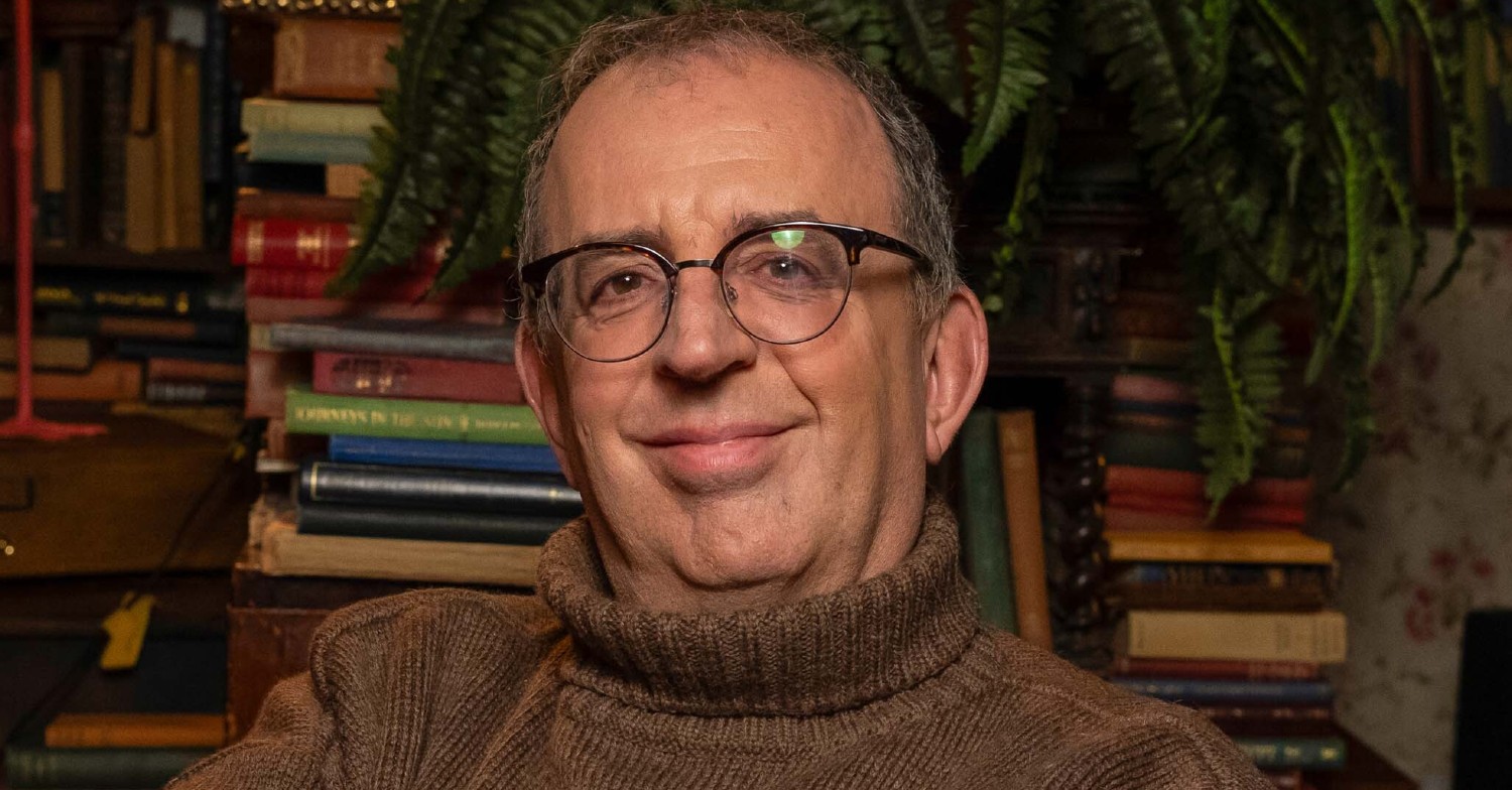 Reverend Richard Coles smiling wearing glasses and a turtleneck jumper