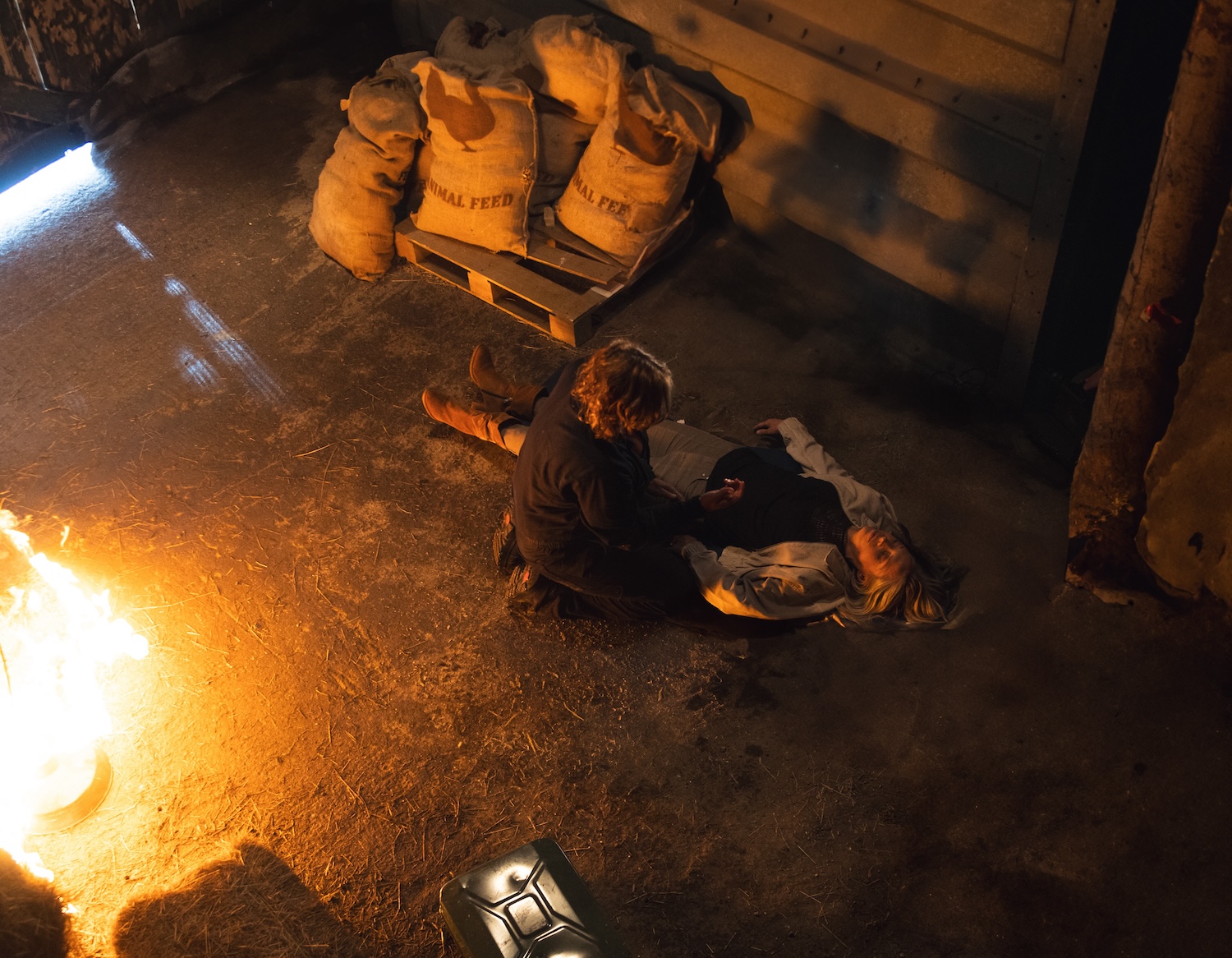 Ruby on the ground as Moira looks on with a fire raging in the barn on Emmerdale