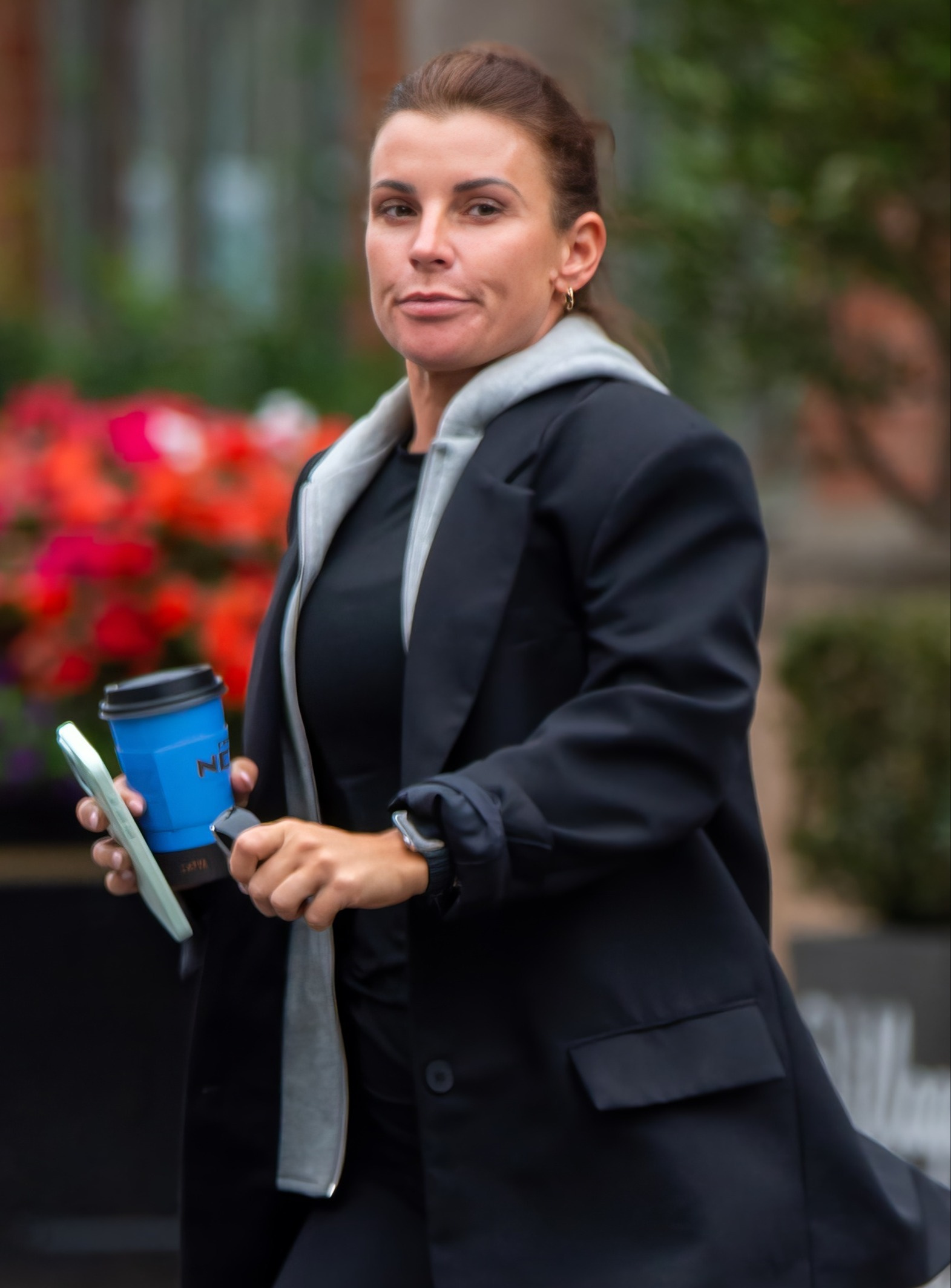 Coleen Rooney looking unhappy holding a coffee