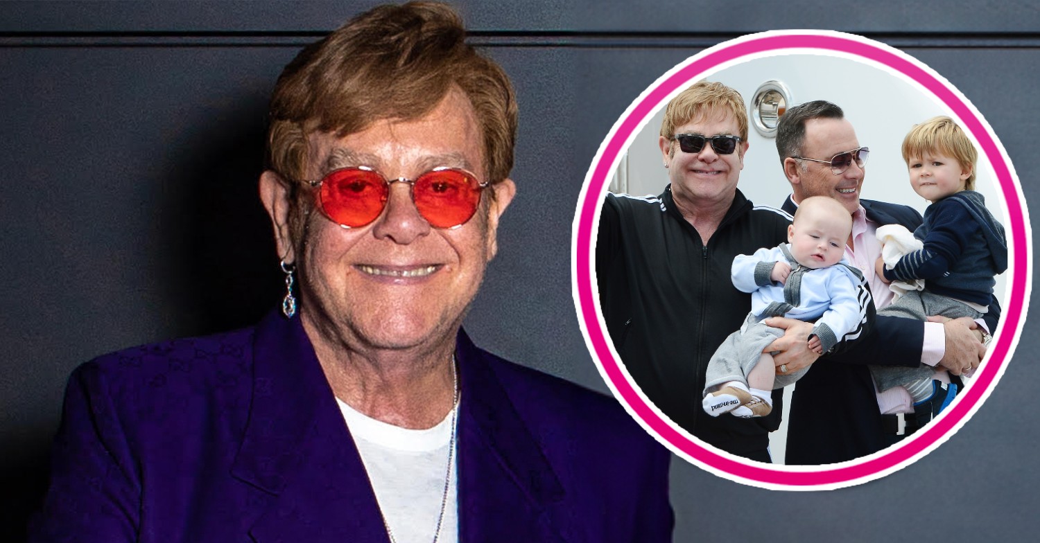 Elton John smiling alongside photo of his husband David and children