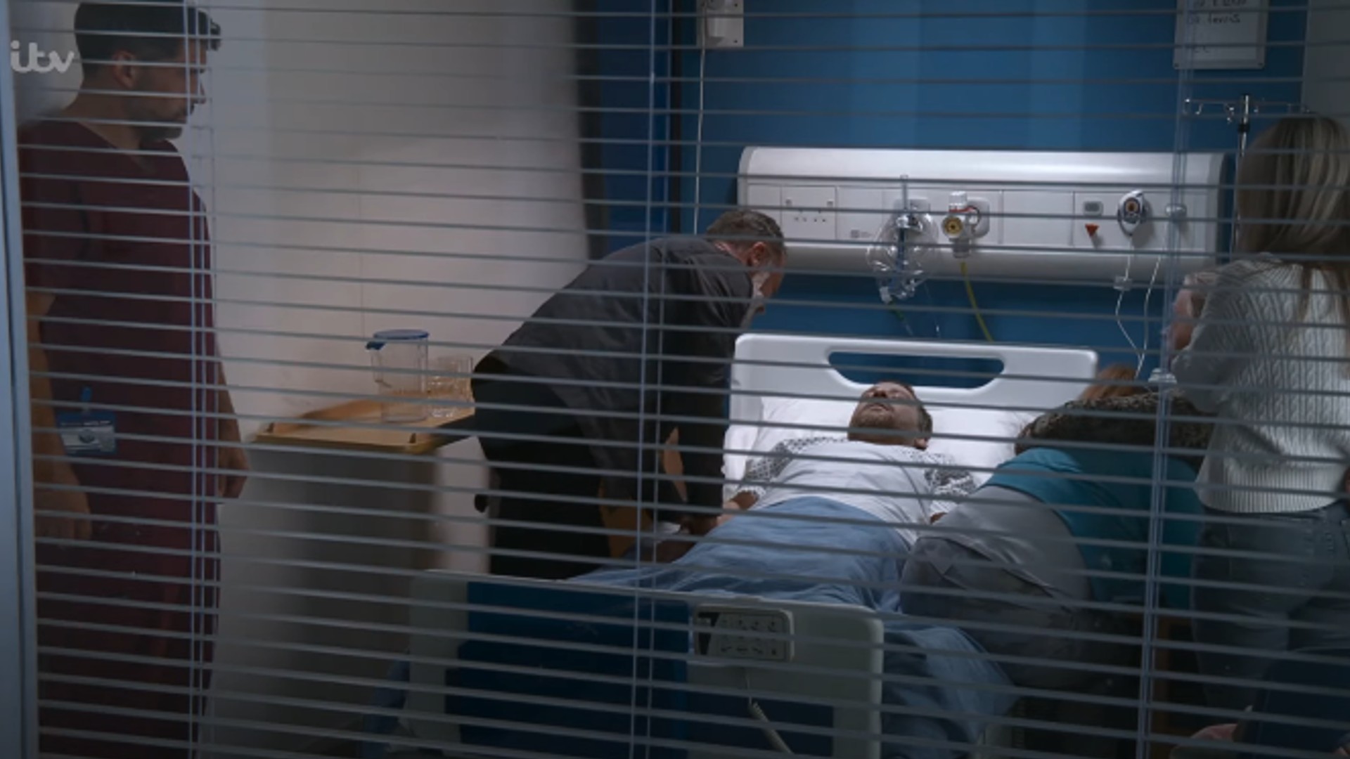 View of Billy at Paul's side in hospital on Corrie