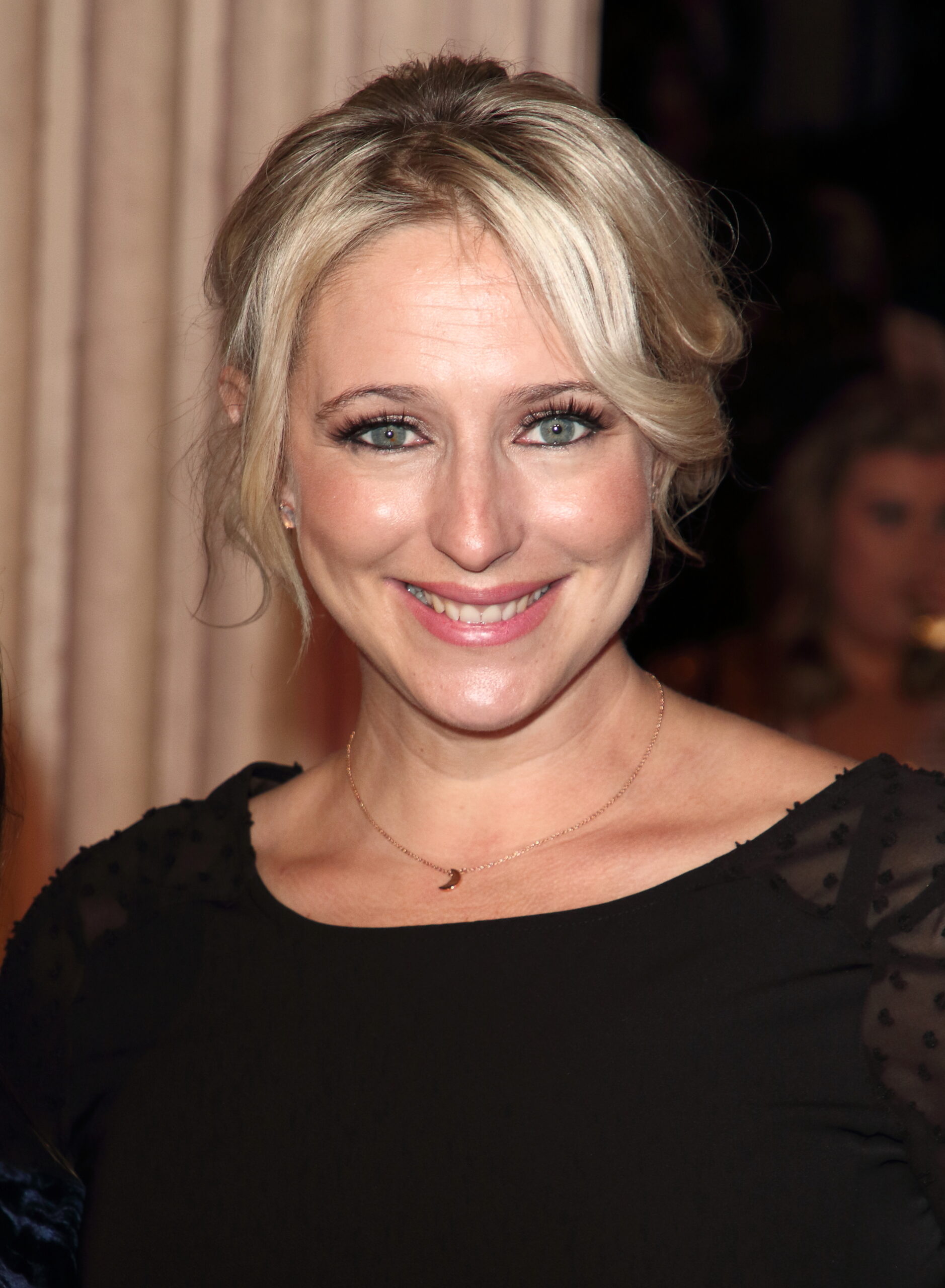 Ali Bastian smiling at event