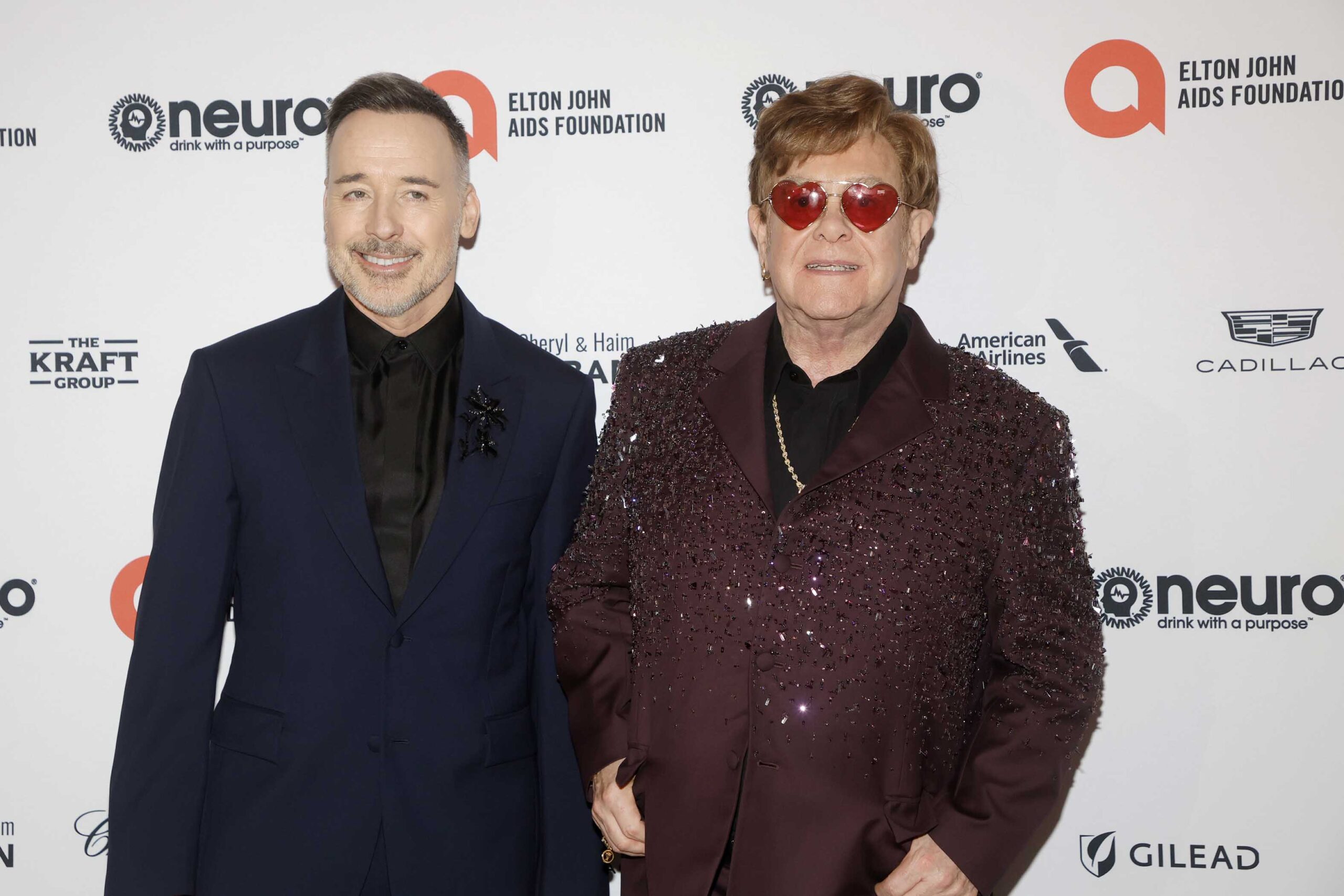 Elton John and his husband David Furnish smiling at event