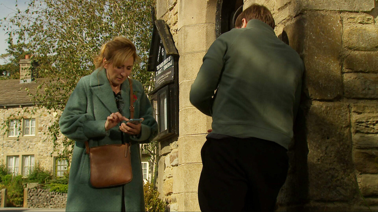 Laurel is on her phone whilst talking to Tom