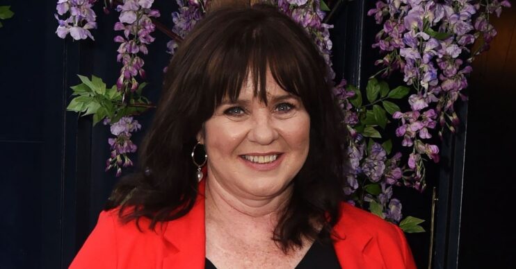 Coleen Nolan smiling in red blazer at event