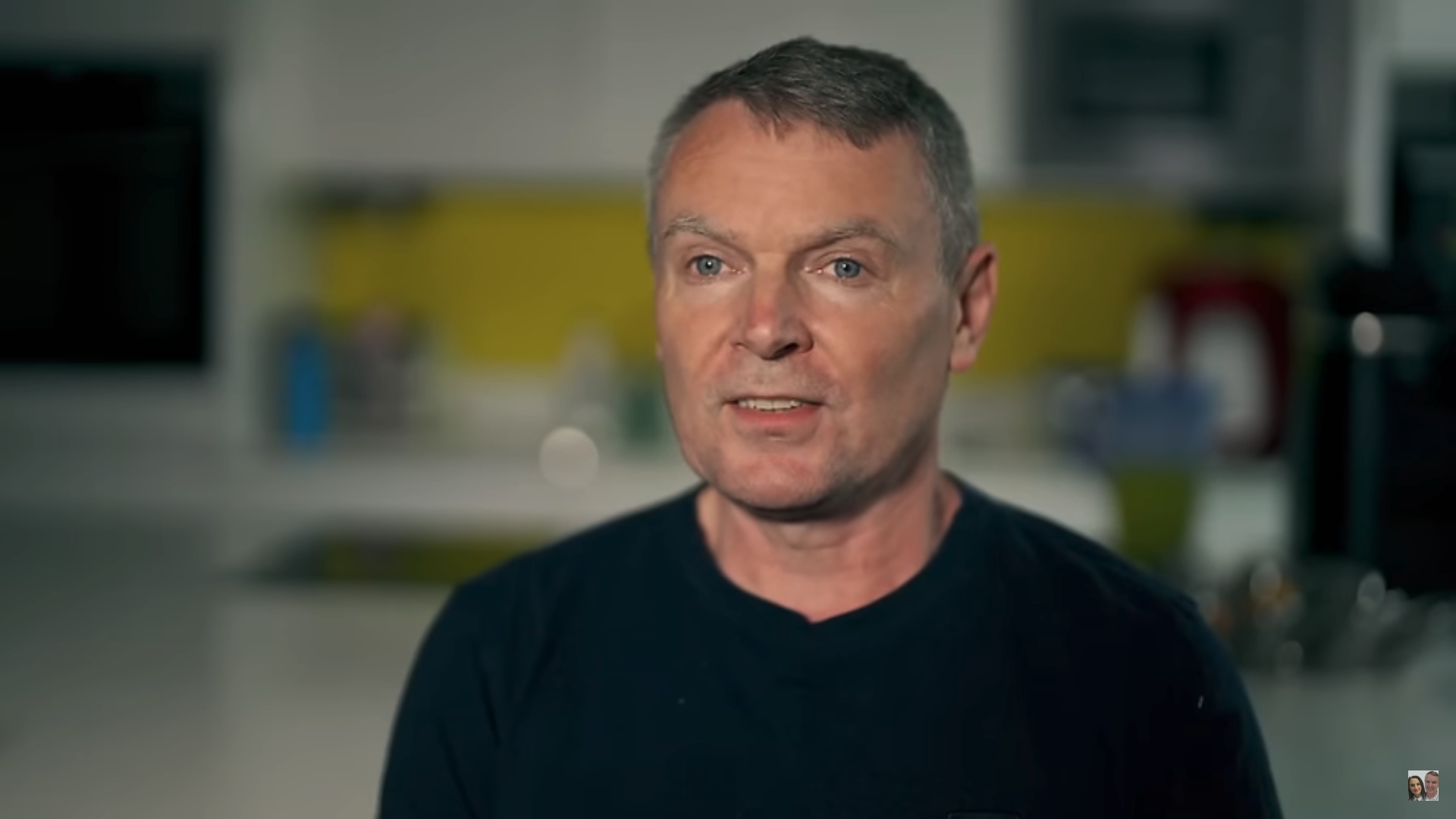 Noel in a black jumper speaking to camera