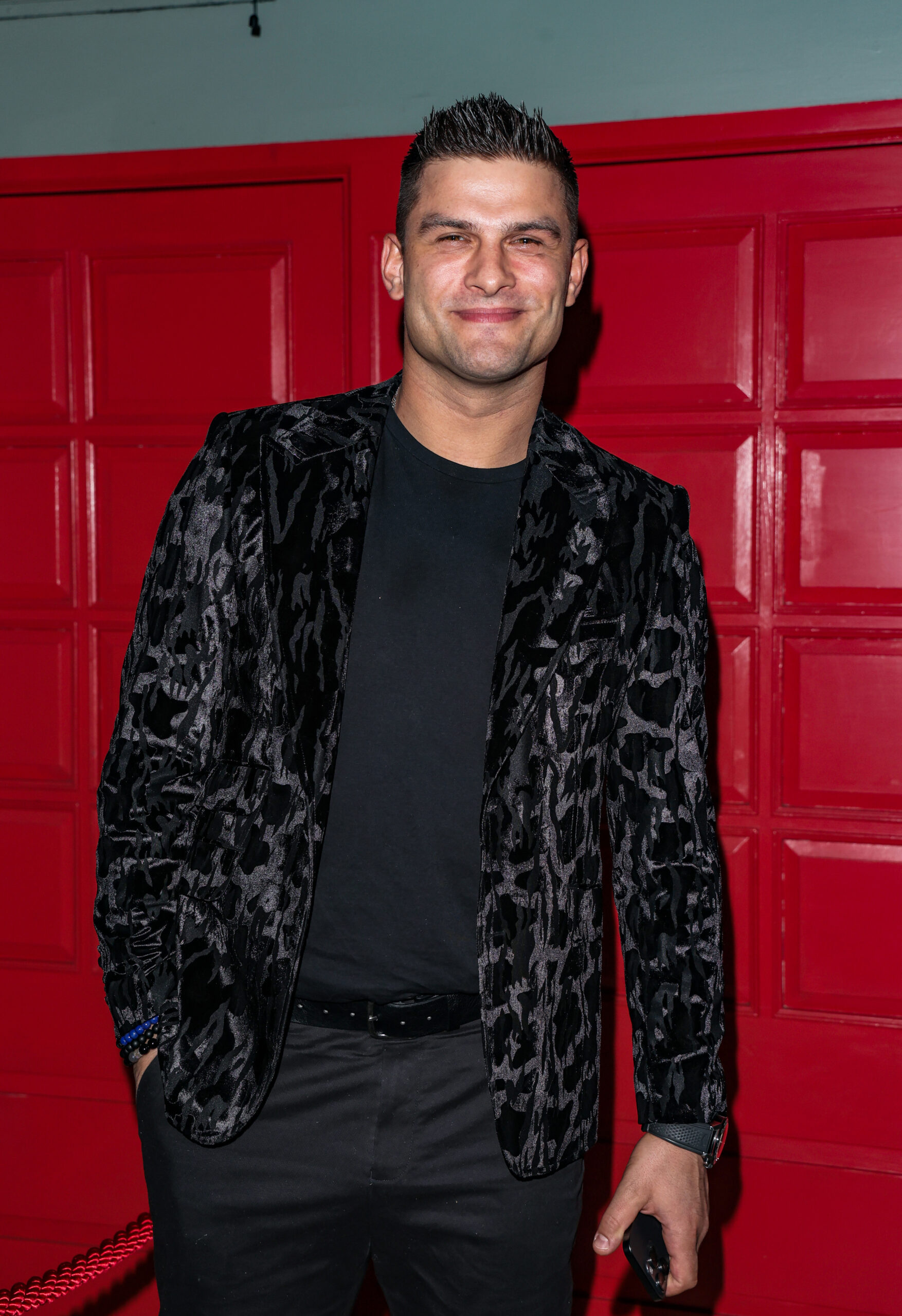 Aljaz Skorjanec standing against a red panelled wall