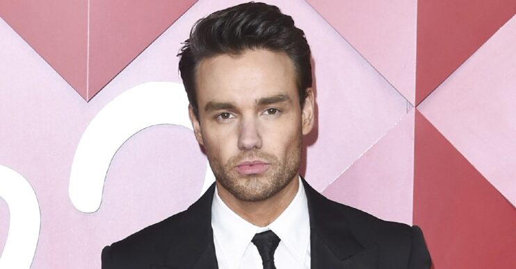 Liam Payne posing in black suit at event